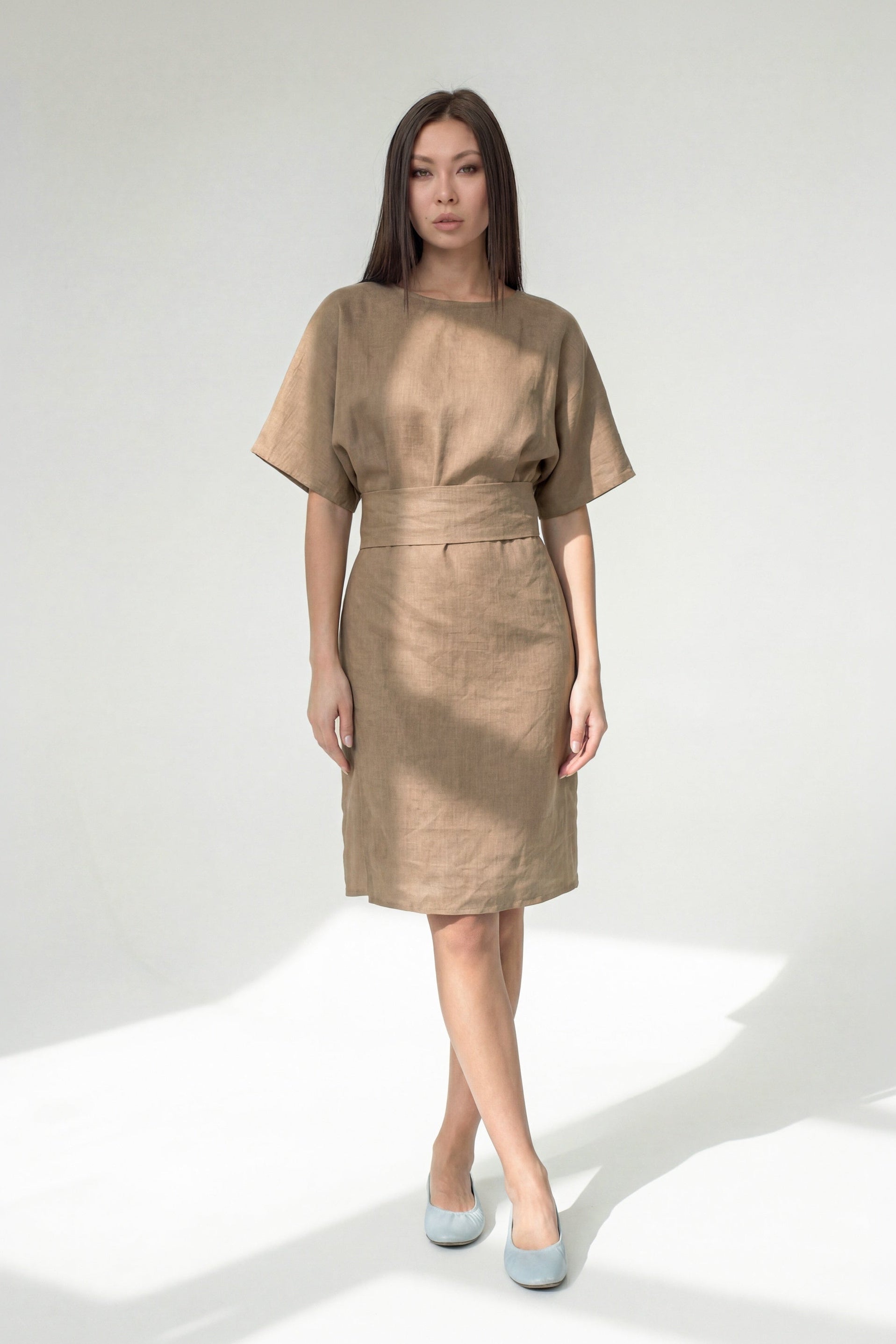 Woman wearing a beige dress on a white background