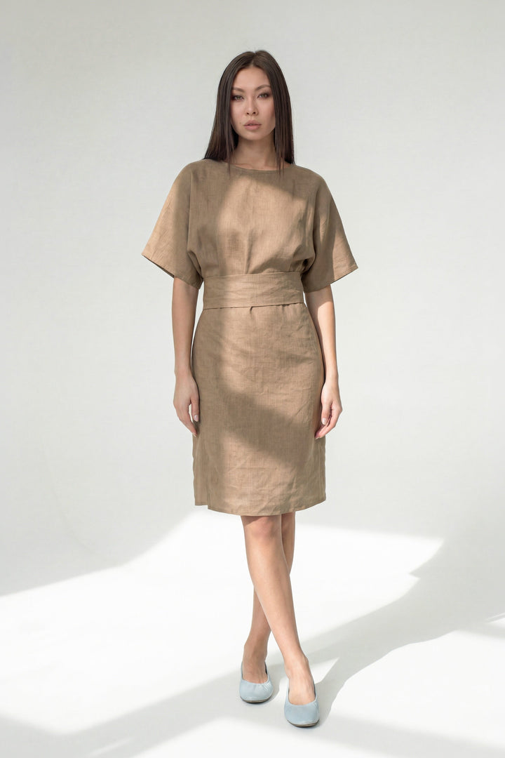 Woman wearing a beige dress on a white background